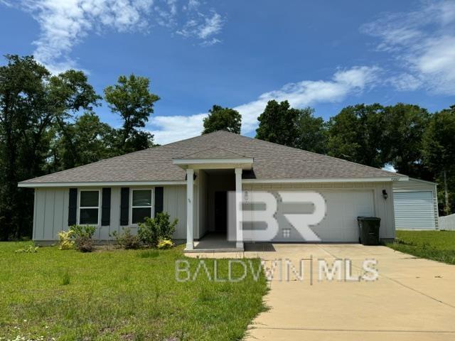 32807 N Pickens Ave, Lillian, AL 36549 - ranch-style house with concrete driveway, a front lawn, an attached garage, and roof with shingles