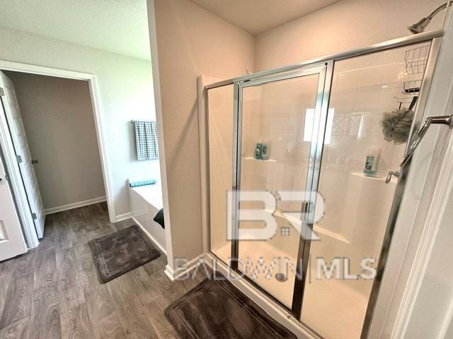 32807 N Pickens Ave, Lillian, AL 36549 - bathroom featuring wood finished floors, a stall shower, and a bath
