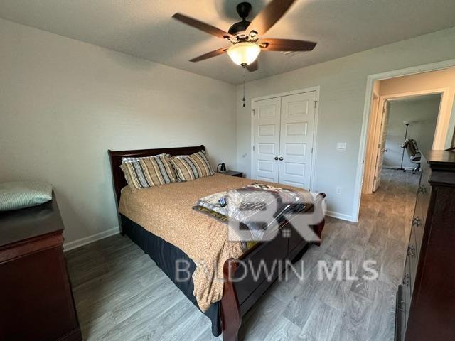 32807 N Pickens Ave, Lillian, AL 36549 - bedroom with wood finished floors, baseboards, a closet, and a ceiling fan