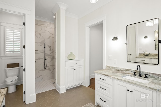 bathroom with a tile shower, toilet, tile patterned floors, vanity, and crown molding