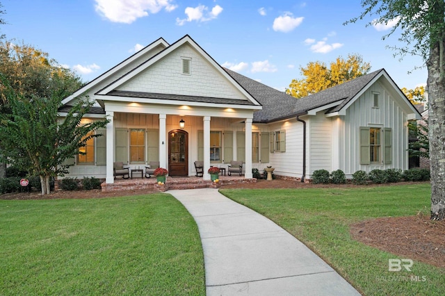 view of front of house with covered porch and a front lawn