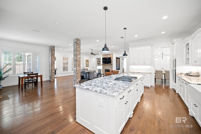 kitchen with hardwood / wood-style floors, a center island, pendant lighting, white cabinetry, and ceiling fan