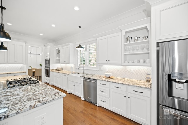 kitchen with white cabinets, light wood-type flooring, stainless steel appliances, sink, and decorative light fixtures