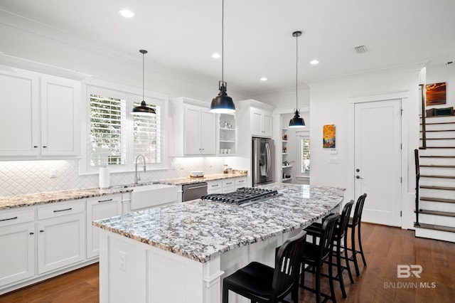 kitchen with dark hardwood / wood-style flooring, white cabinets, sink, and a kitchen island