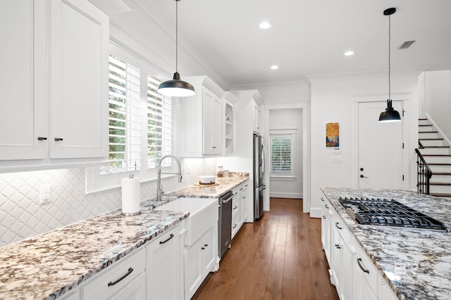 kitchen featuring appliances with stainless steel finishes, white cabinetry, backsplash, and dark hardwood / wood-style flooring