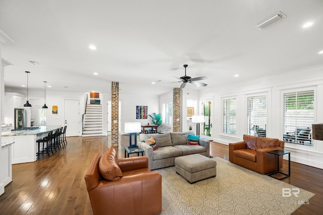 living room featuring ceiling fan, ornamental molding, and light hardwood / wood-style flooring