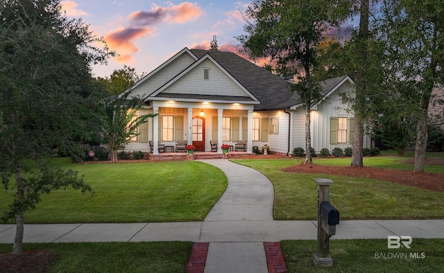 view of front of house with a yard and a porch