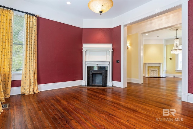 251 S Georgia Ave, Mobile, AL 36604 - unfurnished living room featuring a chandelier, a high end fireplace, plenty of natural light, and hardwood / wood-style floors