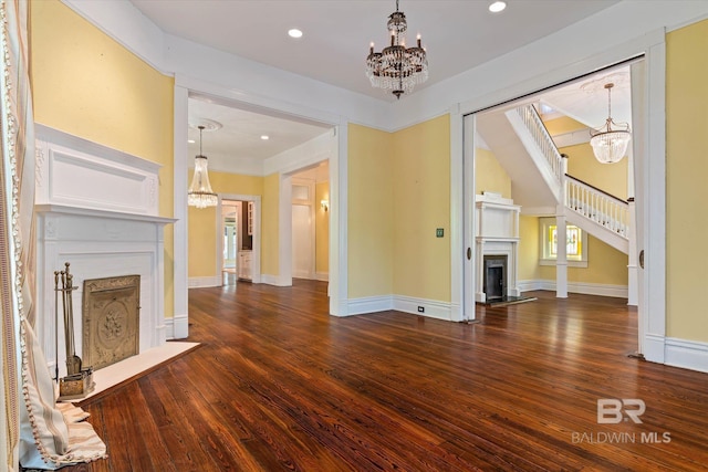251 S Georgia Ave, Mobile, AL 36604 - unfurnished living room featuring a chandelier, a fireplace with flush hearth, and wood finished floors