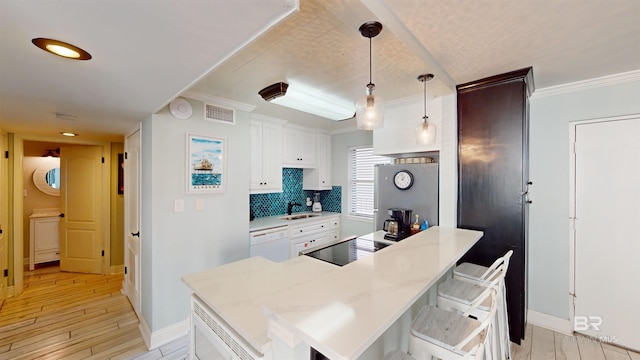 511 E Beach Blvd Unit 503, Gulf Shores, AL 36542 - kitchen with a kitchen bar, baseboards, a sink, light countertops, and ornamental molding