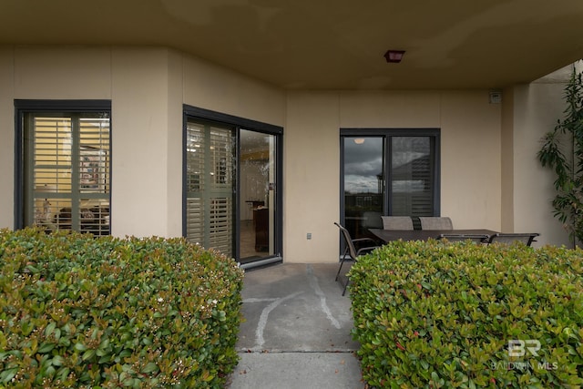 doorway to property with stucco siding and a patio