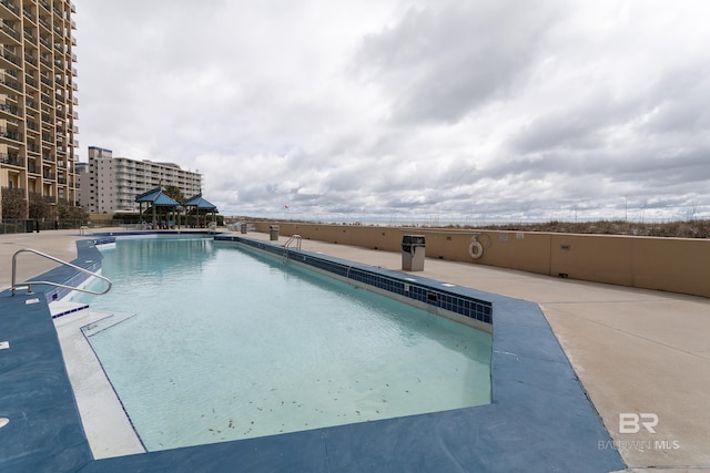 community pool featuring a patio area and a view of city