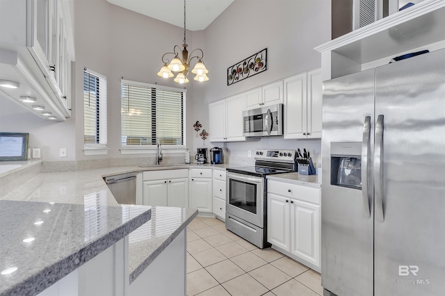 201 W 13th St Unit 2 B, Gulf Shores, AL 36542 - kitchen with appliances with stainless steel finishes, a towering ceiling, a sink, a chandelier, and white cabinetry