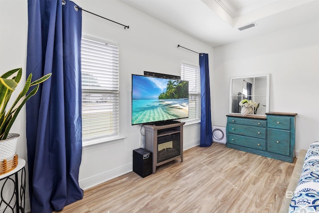 bedroom featuring ornamental molding, visible vents, light wood-style flooring, and baseboards