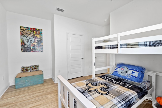 bedroom featuring light wood-type flooring, baseboards, and visible vents