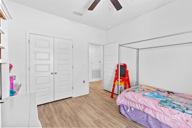 bedroom featuring light wood-type flooring, ceiling fan, visible vents, and a closet