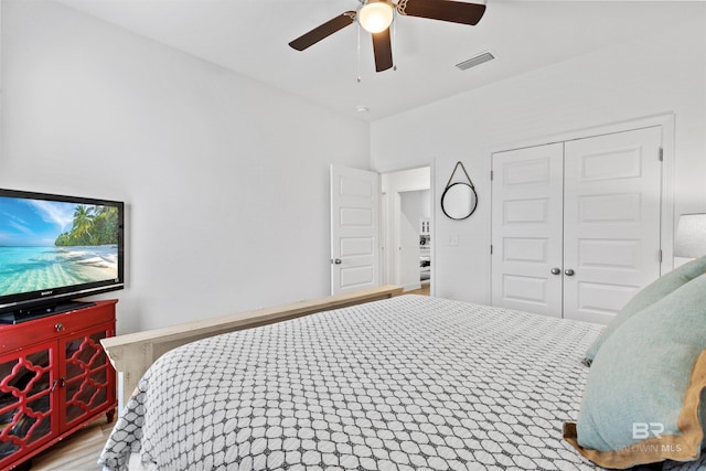 bedroom with a closet, visible vents, ceiling fan, and wood finished floors