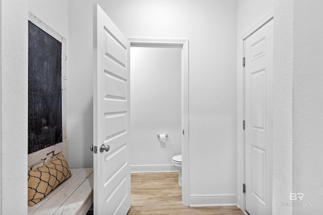 bathroom with baseboards, toilet, and wood finished floors