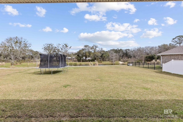 view of yard featuring a trampoline and fence