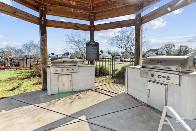 view of patio / terrace with exterior kitchen, a fenced backyard, and a grill