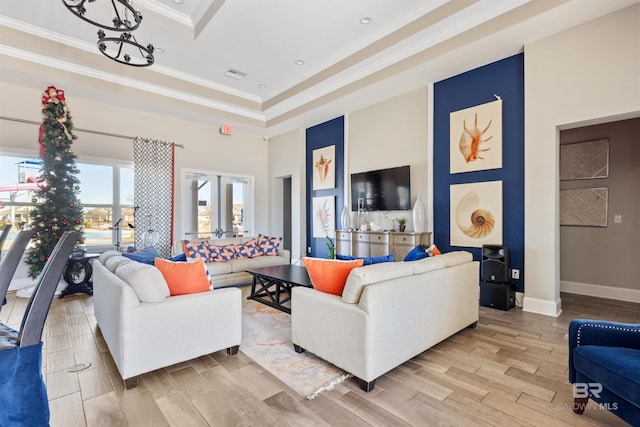 living room featuring light wood finished floors, baseboards, visible vents, ornamental molding, and french doors