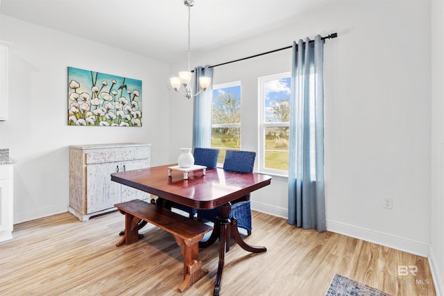 dining room featuring a chandelier, light wood-style flooring, and baseboards