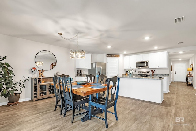 dining area featuring light wood finished floors, recessed lighting, a chandelier, and baseboards