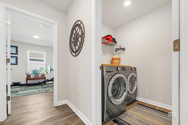 laundry room featuring washing machine and dryer, wood finished floors, baseboards, and recessed lighting