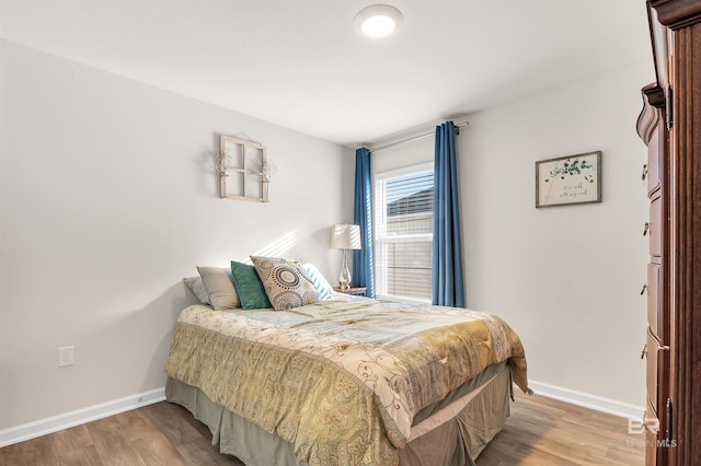 bedroom featuring baseboards and wood finished floors