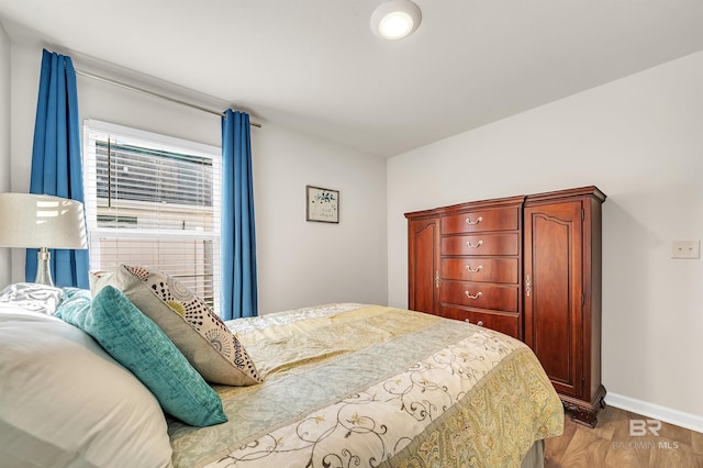 bedroom with wood finished floors and baseboards