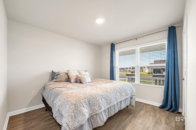 bedroom with baseboards and wood finished floors