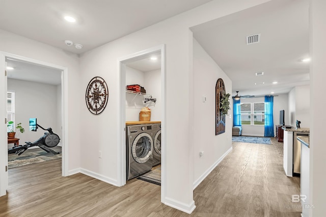 hallway with light wood-style floors, washer and clothes dryer, baseboards, and recessed lighting