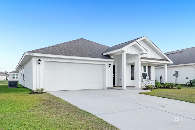 view of front of home with central air condition unit, covered porch, a garage, and roof with shingles