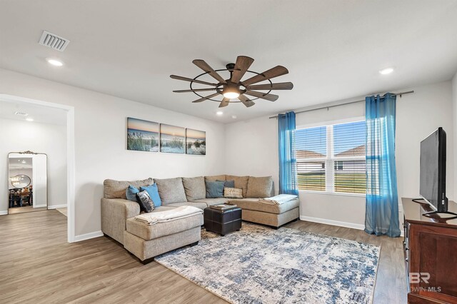 living room featuring a ceiling fan, light wood finished floors, baseboards, and recessed lighting