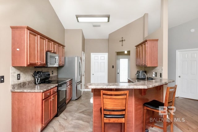 10234 Scott Plantation Dr, Mobile, AL 36695 - kitchen featuring stainless steel appliances, backsplash, a breakfast bar, a peninsula, and light countertops