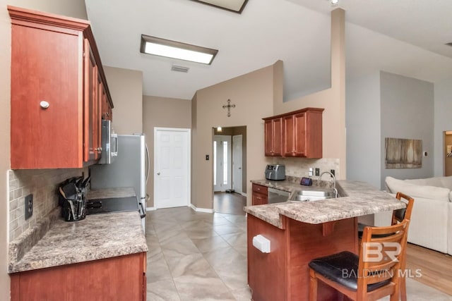10234 Scott Plantation Dr, Mobile, AL 36695 - kitchen with backsplash, a kitchen breakfast bar, a peninsula, open floor plan, and appliances with stainless steel finishes