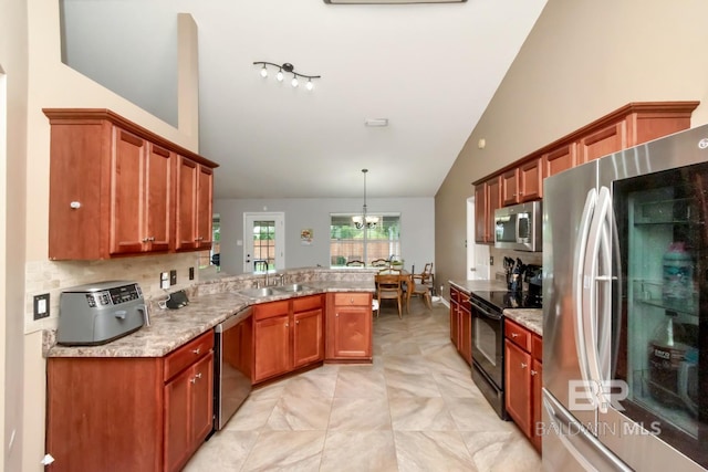 10234 Scott Plantation Dr, Mobile, AL 36695 - kitchen with appliances with stainless steel finishes, a peninsula, a chandelier, brown cabinets, and high vaulted ceiling