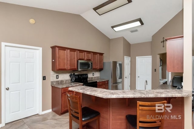 10234 Scott Plantation Dr, Mobile, AL 36695 - kitchen with appliances with stainless steel finishes, a breakfast bar area, high vaulted ceiling, backsplash, and brown cabinets