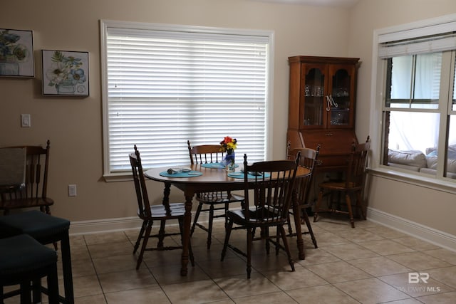 dining room with light tile patterned floors, baseboards, and a healthy amount of sunlight