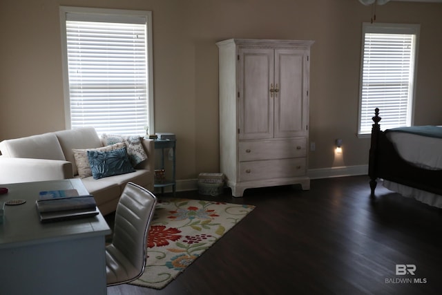 bedroom with multiple windows, dark wood-style floors, and baseboards