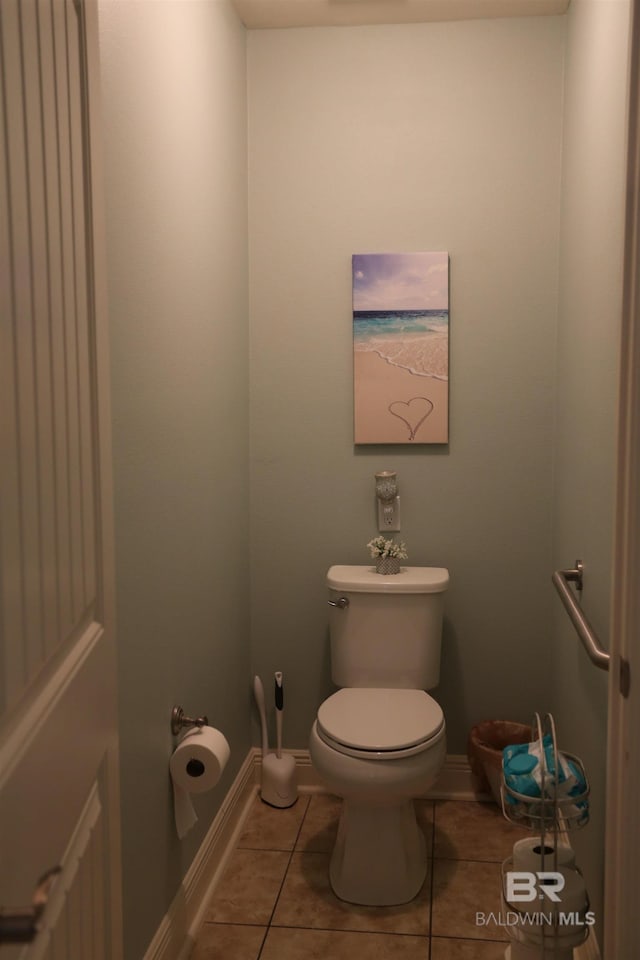 bathroom featuring tile patterned floors, toilet, and baseboards