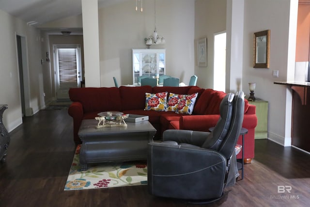 living area featuring a notable chandelier, wood finished floors, baseboards, and high vaulted ceiling