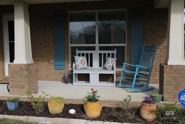 property entrance with brick siding and a porch