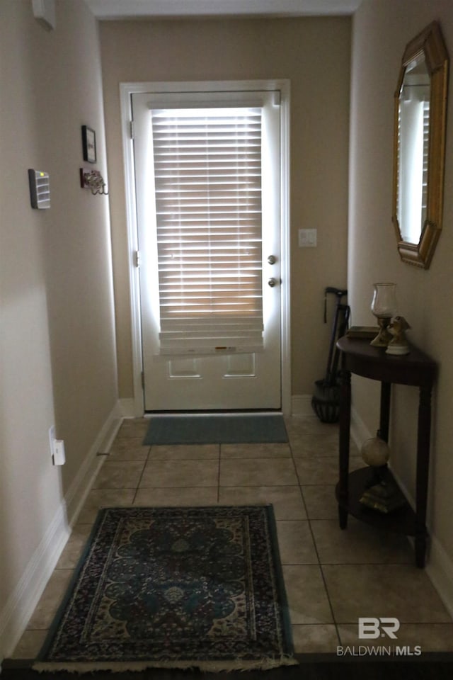 entryway with light tile patterned floors and baseboards