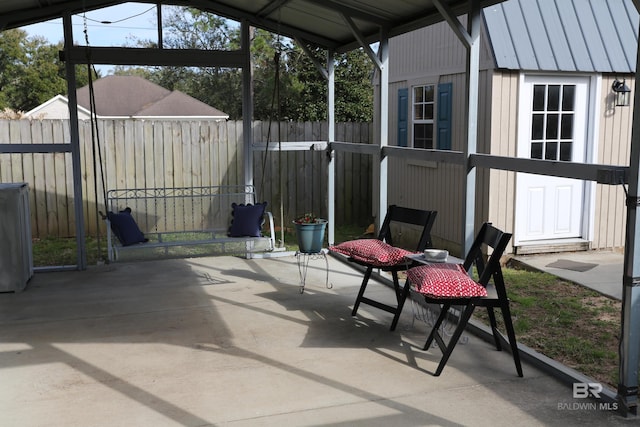 view of patio / terrace with an outbuilding and fence