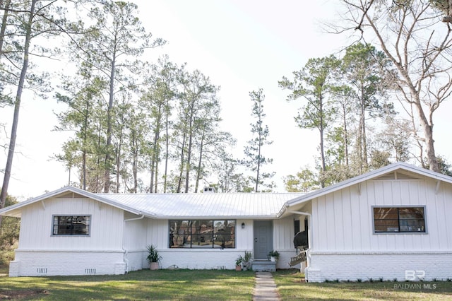 single story home featuring crawl space, a front yard, metal roof, and brick siding