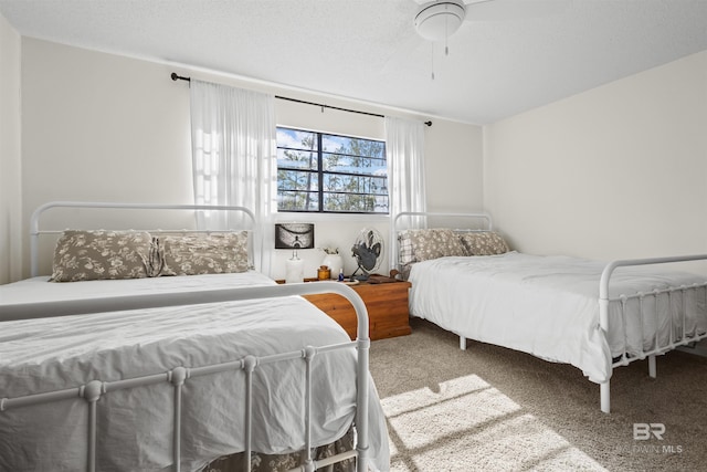 carpeted bedroom with ceiling fan and a textured ceiling