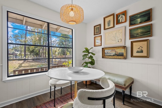 dining area featuring breakfast area, a wainscoted wall, and wood finished floors