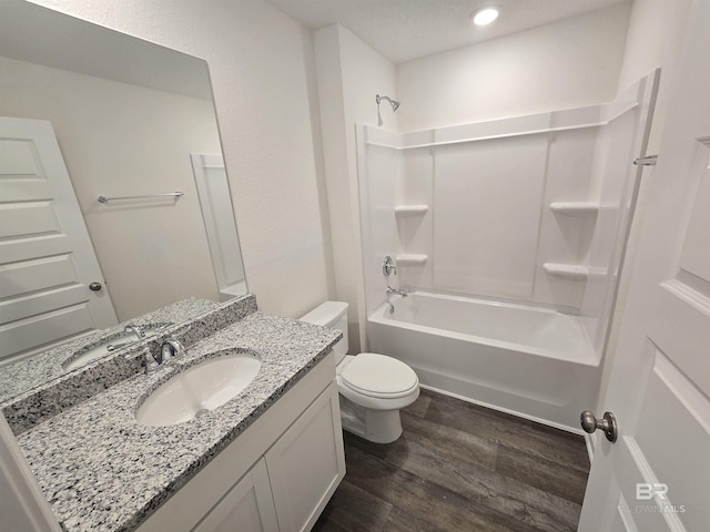 bathroom featuring toilet, vanity, shower / tub combination, and wood finished floors