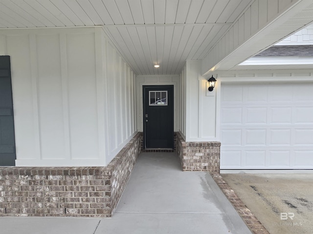 entrance to property featuring a garage and brick siding